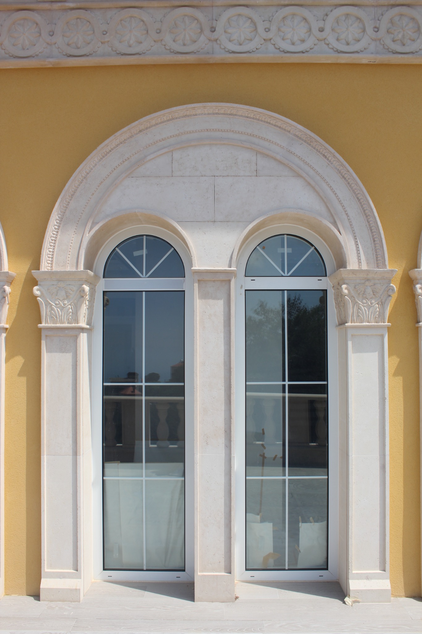 Classical stone arch and columns framing two tall windows