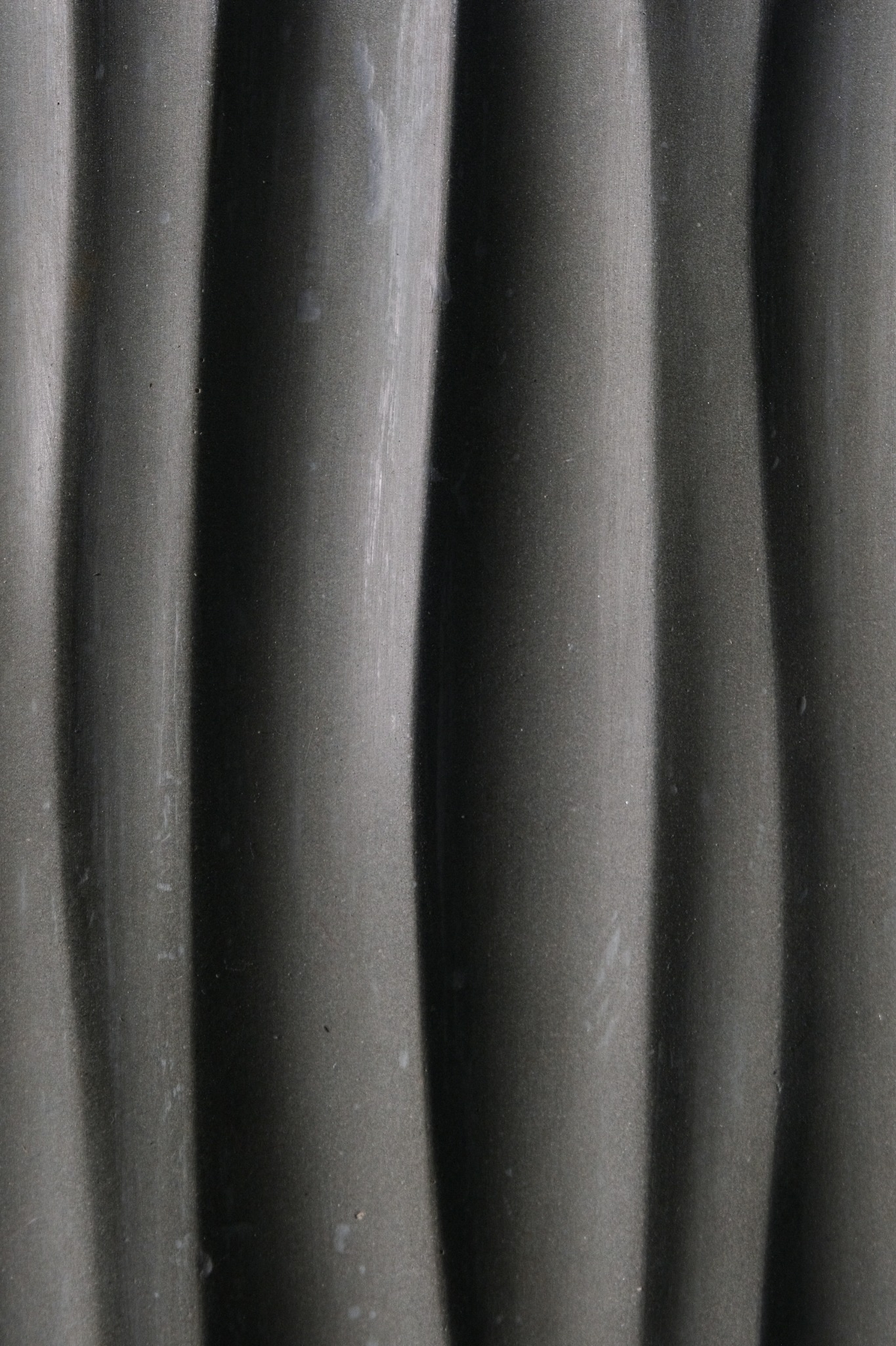Close view of a dark fluted UHPC surface